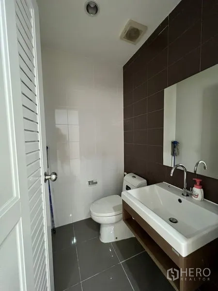 ทาวน์เฮาส์ ขายในBang Kapi, Bangkok - ห้องน้ำรับแขกพร้อมอ่างล้างหน้า กระจก และโถสุขภัณฑ์