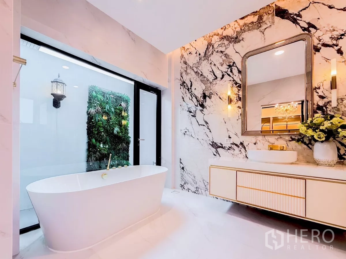Detached House for rent in Saphan Sung, Bangkok - Luxury bathroom with freestanding tub, marble feature wall and garden view window.