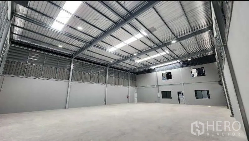 Factory for rent in Bang Bo, Samut Prakan - High-clearance warehouse interior with steel truss roof and skylights