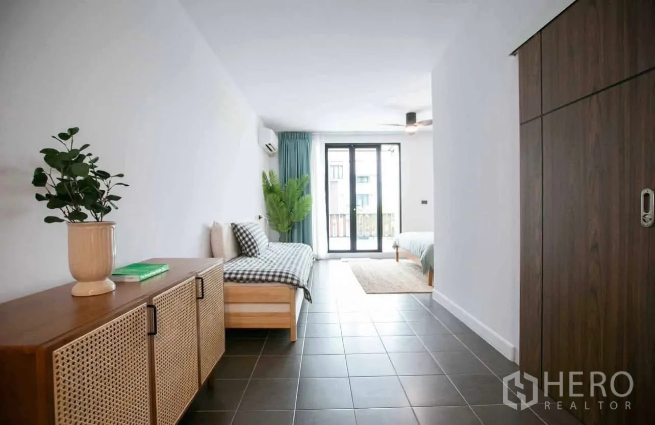 Townhouse for rent in Suan Luang, Bangkok - Bright room with daybed, wardrobe and balcony doors over tiled flooring.
