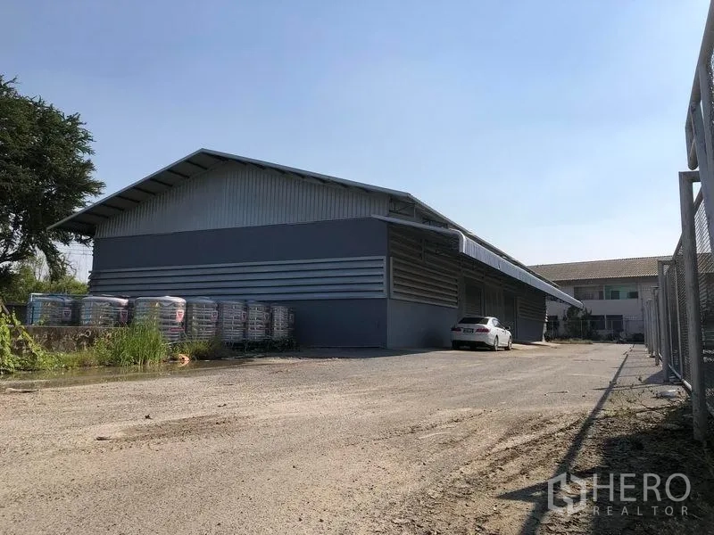 工厂 出租在Bang Bua Thong, Nonthaburi - 工厂外观广角图，带车道与围栏边界。