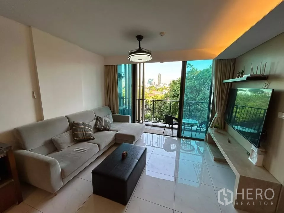 คอนโด ให้เช่าในWatthana, Bangkok - ห้องนั่งเล่นสว่างเปิดออกสู่ระเบียง เห็นวิวต้นไม้และเมือง