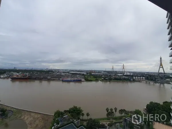 Condominium for rent in Yan Nawa, Bangkok - High-floor balcony view of the Chao Phraya River and Bhumibol Bridge.