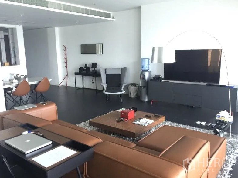 Condominium for rent or sale in Pathum Wan, Bangkok - Open-plan lounge with leather sofa, media wall and coffee table