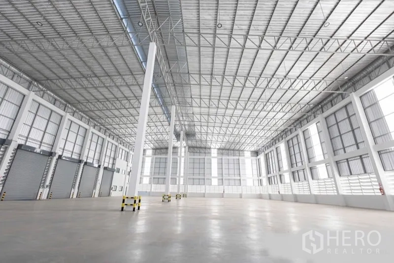 Warehouse for rent in Bang Bo, Samut Prakan - Large open storage hall with polished concrete floor, tall windows and ample natural light.