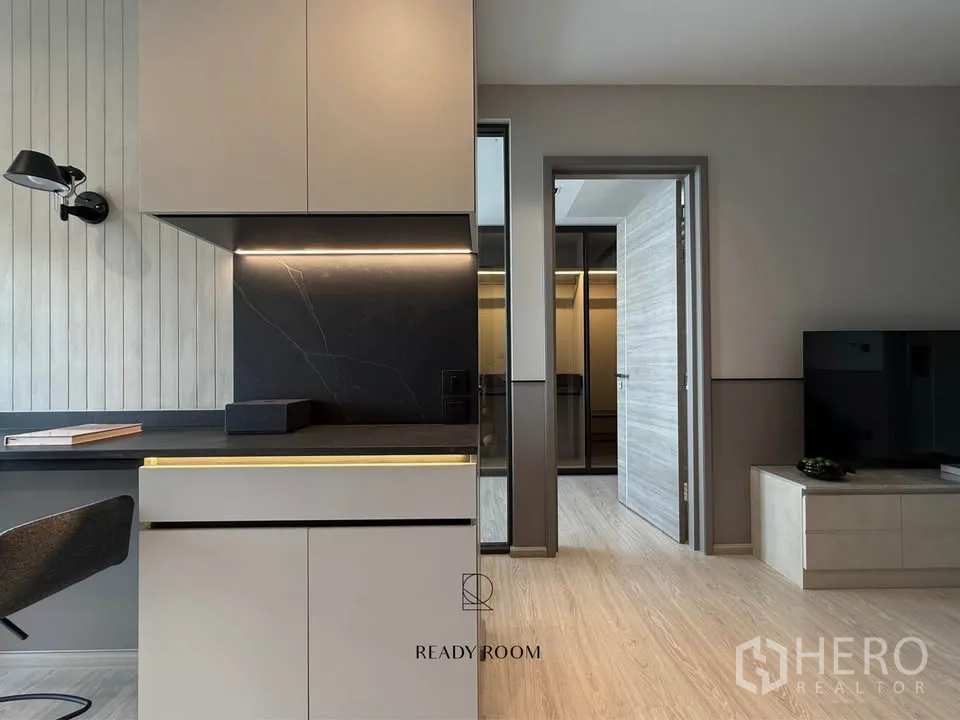 คอนโด for rent in Khlong Toei, Bangkok - เคาน์เตอร์ครัวท็อปหินสีดำ ไฟใต้ตู้ และทางเดินสู่ห้องนอน