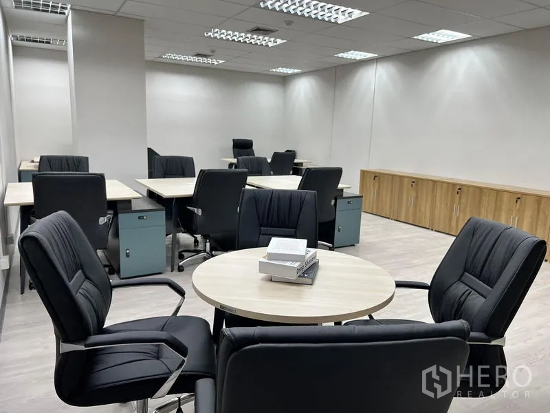 Office Space for rent in Sathon, Bangkok - Wide view of the office showing multiple desks, ceiling grid lights and full-length built-in cabinets.