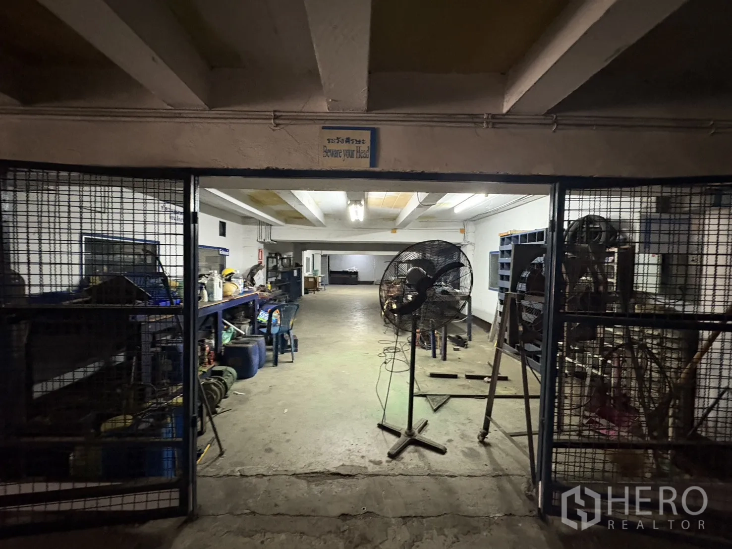 工厂 出租在Phra Pradaeng, Samut Prakan - 地下车间，带网笼式储物与工业风扇。