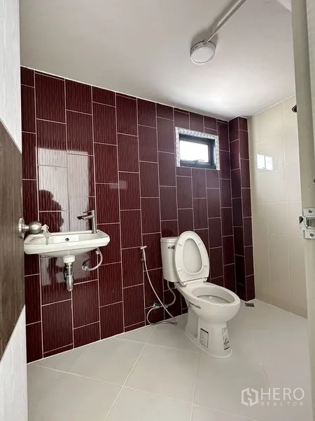 工厂 出租或出售在Sai Noi, Nonthaburi - 整洁卫生间，白色洁具搭配酒红色墙砖。