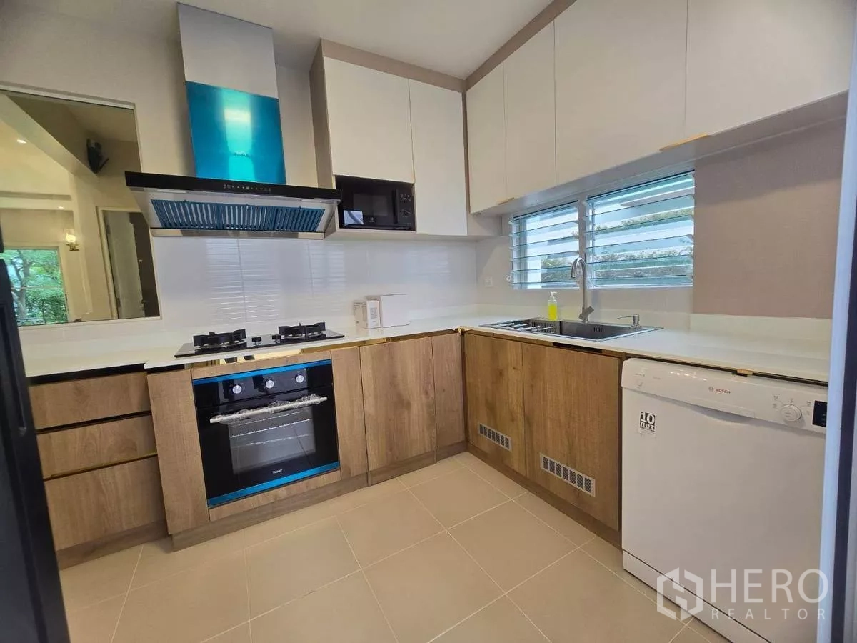 Detached House for rent in Bang Phli, Samut Prakan - Modern L-shaped kitchen with gas hob, oven, extractor hood, dishwasher and window.