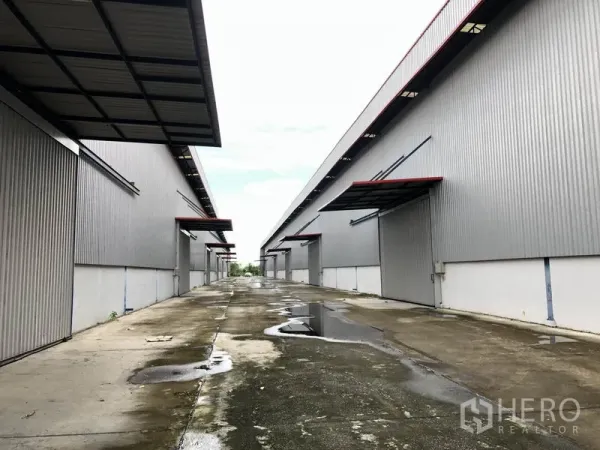 โรงงาน ให้เช่าหรือขายในPhra Nakhon Si Ayutthaya - เลนบริการหลังฝนตก เห็นจุดโหลดสินค้าทั้งสองฝั่งของโกดัง