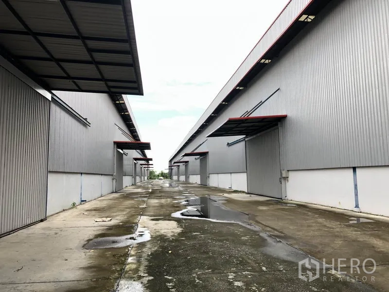 โรงงาน ให้เช่าหรือขายในPhra Nakhon Si Ayutthaya - เลนบริการหลังฝนตก เห็นจุดโหลดสินค้าทั้งสองฝั่งของโกดัง