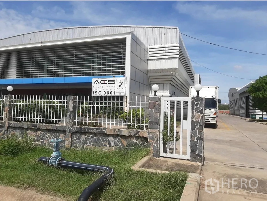 Factory for rent in Uthai, Phra Nakhon Si Ayutthaya - Gated factory exterior with metal facade, louvered windows, and a truck driveway.