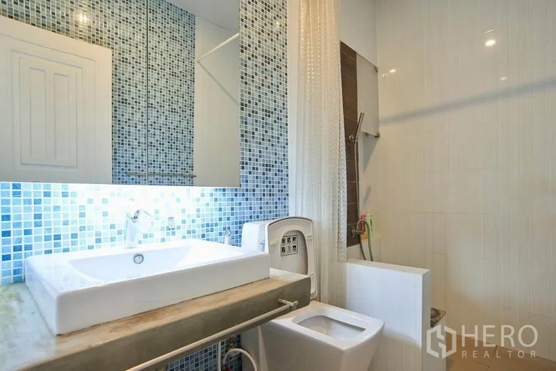 带办公室的家 出租在Wang Thonglang, Bangkok - 明亮卫生间，蓝色马赛克墙与方形台上盆、淋浴区