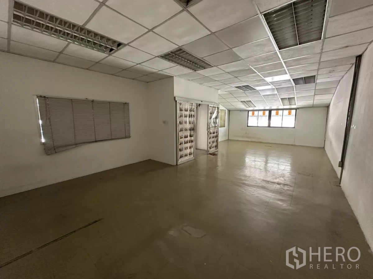 Warehouse for rent in Suan Luang, Bangkok - Second-floor office room with drop ceiling, fluorescent lights and windows.