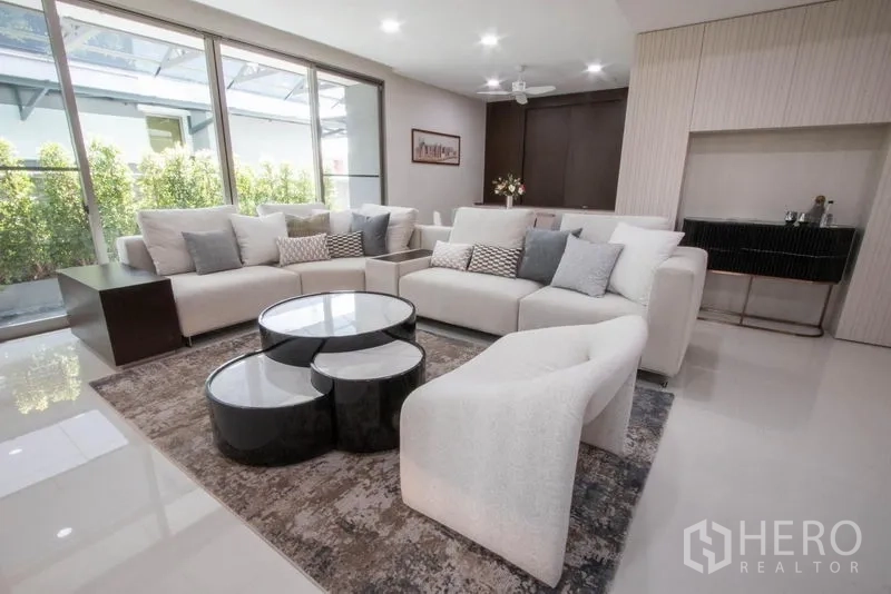 Detached House for sale in Saphan Sung, Bangkok - Spacious living area with sectional sofas, designer coffee tables and floor-to-ceiling windows.