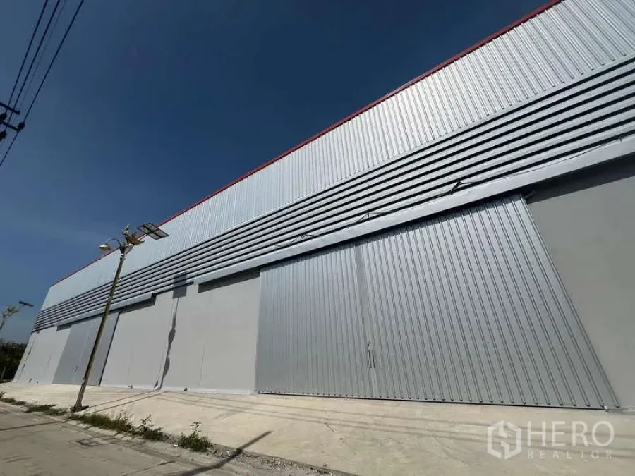 货栈 出租在Prawet, Bangkok - 仓库长立面，特大推拉门与上部通风板。