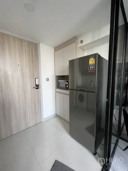 公寓 出租在Sathon, Bangkok - 入户小厨房，吊柜、微波炉和大尺寸不锈钢冰箱。