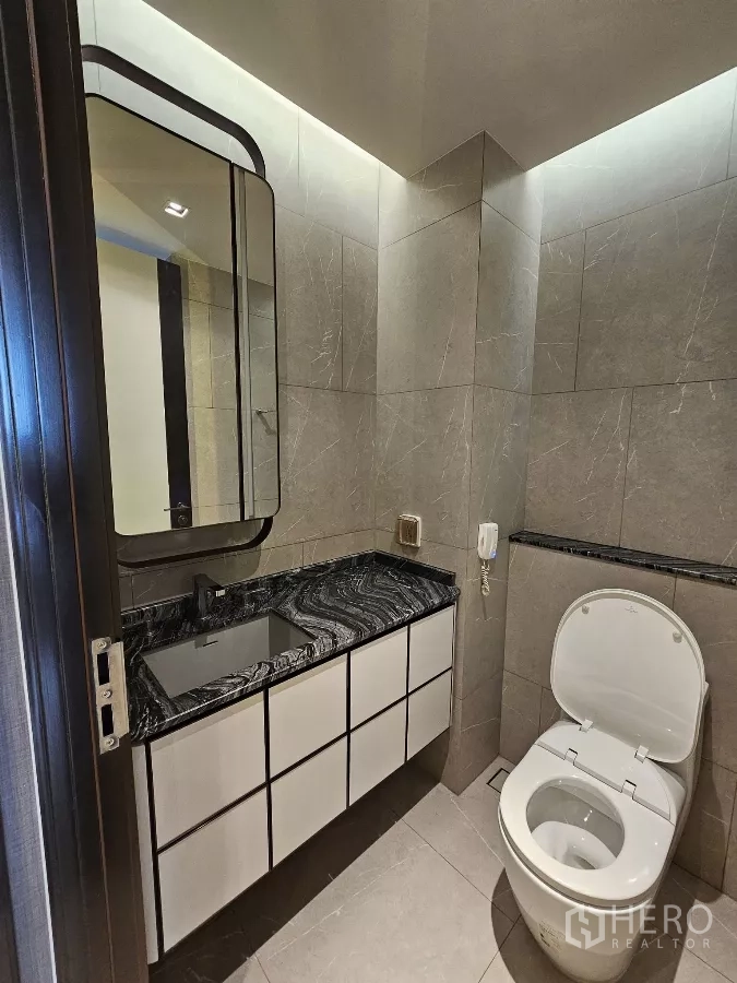 公寓 出租在Watthana, Bangkok - 现代化客卫，黑色石材台面与坐便器。