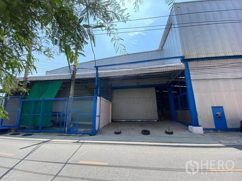 工厂 出租或出售在Bang Sao Thong, Samut Prakan - Bang Sao Thong金属外墙工厂外观，设大型卷闸门与有顶装卸区。
