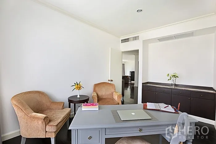 Condominium for rent in Khlong San, Bangkok - Home office nook with desk, two armchairs and built-in cabinetry.