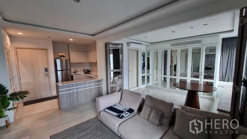 Condominium for sale in Pathum Wan, Bangkok - Open-plan living area with modern kitchen, stone counter and fridge