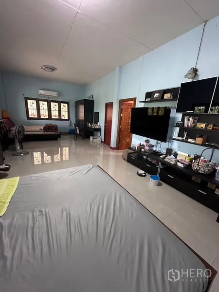 Detached House for sale in Bang Bua Thong, Nonthaburi - Oversized bedroom with media wall, wardrobes and glossy tiled floor.