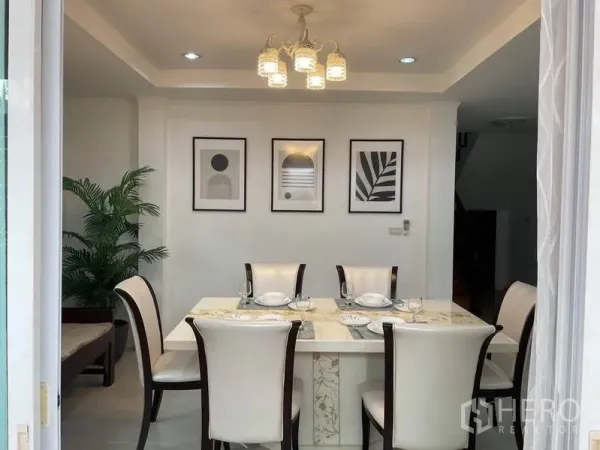 บ้าน ให้เช่าในSuan Luang, Bangkok - ห้องทานอาหารโต๊ะหินอ่อน 6 ที่นั่ง โคมไฟแขวน และกรอบภาพตกแต่งผนัง.