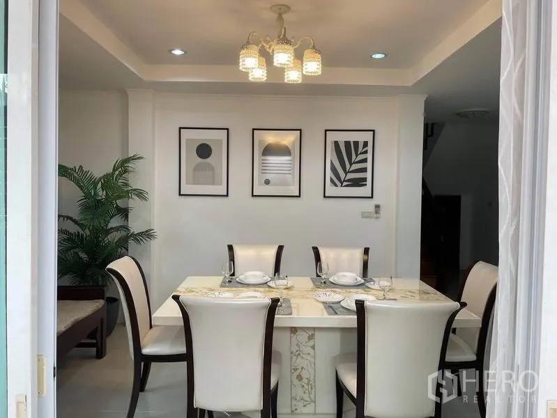 บ้าน ให้เช่าในSuan Luang, Bangkok - ห้องทานอาหารโต๊ะหินอ่อน 6 ที่นั่ง โคมไฟแขวน และกรอบภาพตกแต่งผนัง.