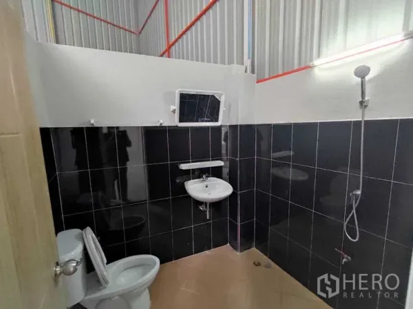 คลังสินค้า ให้เช่าในPak Kret, Nonthaburi - ห้องน้ำโกดัง มีโถสุขภัณฑ์ อ่างล้างหน้า และฝักบัว ผนังกระเบื้องสีดำ