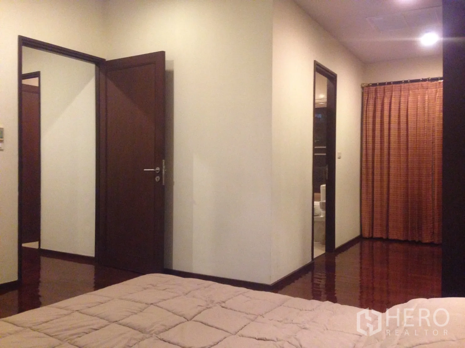 คอนโด ให้เช่าในWatthana, Bangkok - มุมมองจากห้องนอนไปยังโถงทางเดินและห้องน้ำในตัว แสงไฟอบอุ่นและผ้าม่านสูงจรดเพดาน