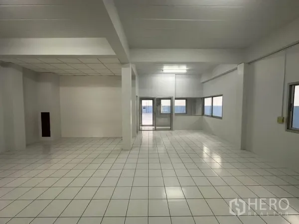 工厂 出租在Pathum Thani - 明亮的瓷砖地面生产/办公区，带窗户和双扇玻璃门。
