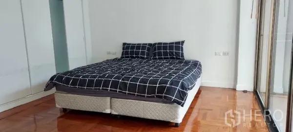 ทาวน์เฮาส์ ให้เช่าในSathon, Bangkok - ห้องนอนสว่าง เตียงคิงไซซ์ พื้นไม้เงา และตู้เสื้อผ้าบิวท์อินติดระเบียง