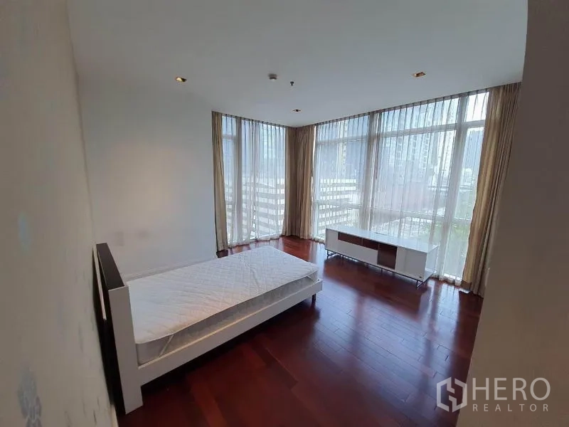 คอนโด ให้เช่าในPathum Wan, Bangkok - ห้องนอนมุมอาคาร พร้อมกระจกเต็มผนัง ผ้าม่านโปร่ง และพื้นไม้สวยงาม