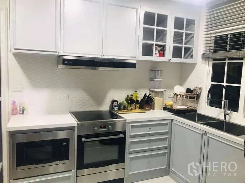 独立式住宅 出租在Chom Thong, Bangkok - L型厨房，内置烤箱、微波炉、抽油烟机及靠窗双水槽。