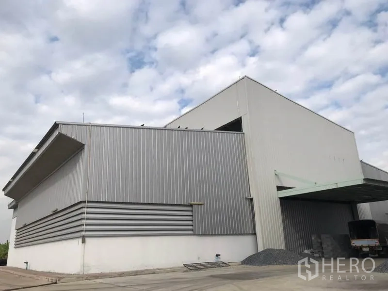 Warehouse for rent in Sai Noi, Nonthaburi - Metal-clad warehouse exterior with large canopy and truck-access driveway.