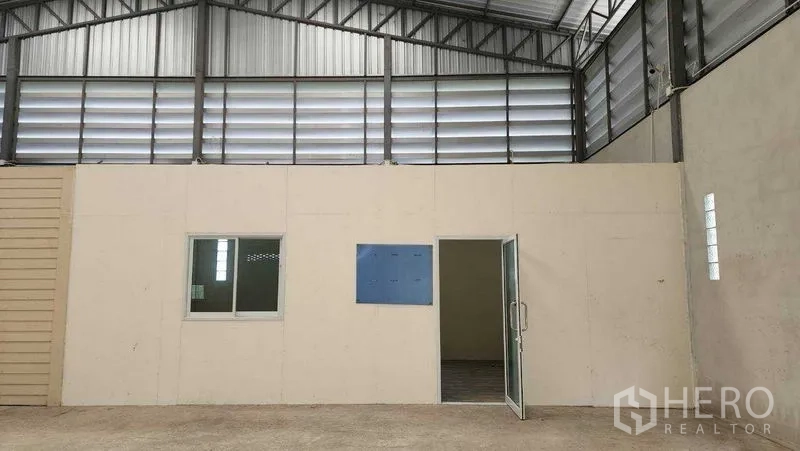 คลังสินค้า ให้เช่าในChon Buri - ผนังกั้นพร้อมหน้าต่าง ตู้ไฟ และประตูเข้าสู่ห้องอเนกประสงค์