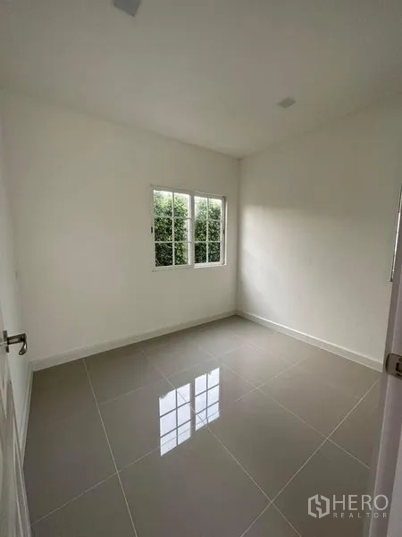 Detached House for rent - Sunlit bedroom with tiled floor and single window.
