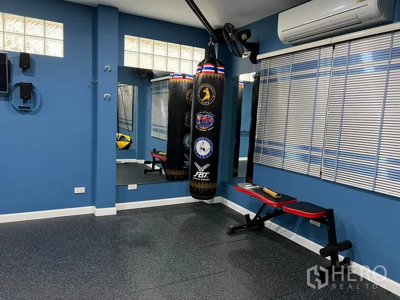 Detached House for rent in Bang Kapi, Bangkok - Boxing and weights corner with punching bags, bench and air conditioning.