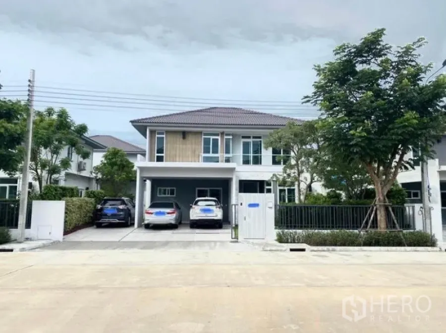 Detached House for rent in Prawet, Bangkok - Front exterior of a modern two-storey detached house in Prawet, Bangkok with gated driveway and covered carport.