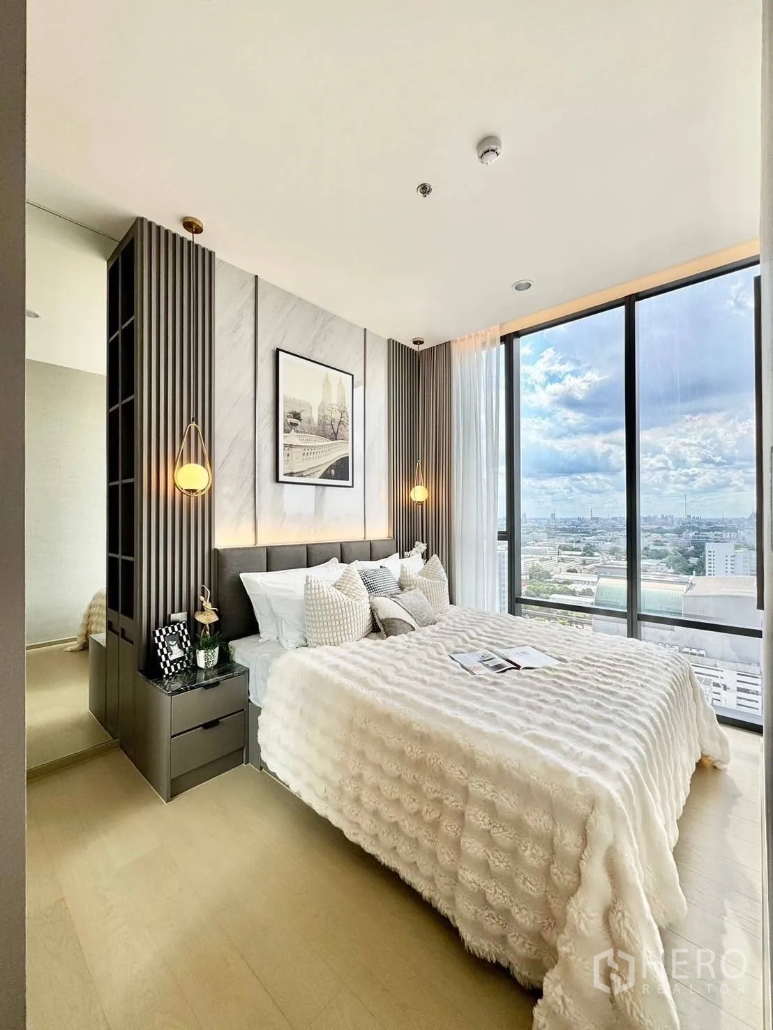 คอนโด for rent in Ratchathewi, Bangkok - ห้องนอนมีหน้าต่างบานใหญ่เห็นวิวเมือง พร้อมโต๊ะข้างเตียงและเครื่องนอนนุ่มสบาย