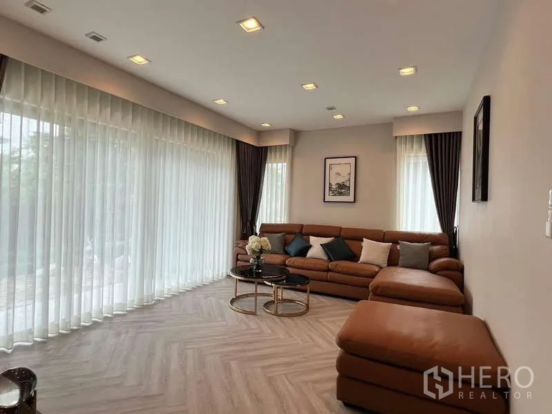 บ้าน ให้เช่าหรือขายในLat Krabang, Bangkok - พื้นที่นั่งเล่น ผ้าม่านโปร่งเต็มผนัง และโซฟามุมขนาดใหญ่