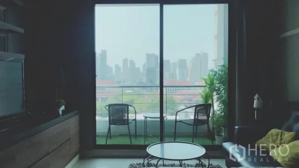 คอนโด ให้เช่าในWatthana, Bangkok - ห้องนั่งเล่นเชื่อมต่อระเบียง มีเก้าอี้สองตัว มองเห็นวิวสกายไลน์กรุงเทพฯ