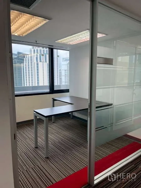 Office Space for rent - Glass-enclosed private office with desk and city view.