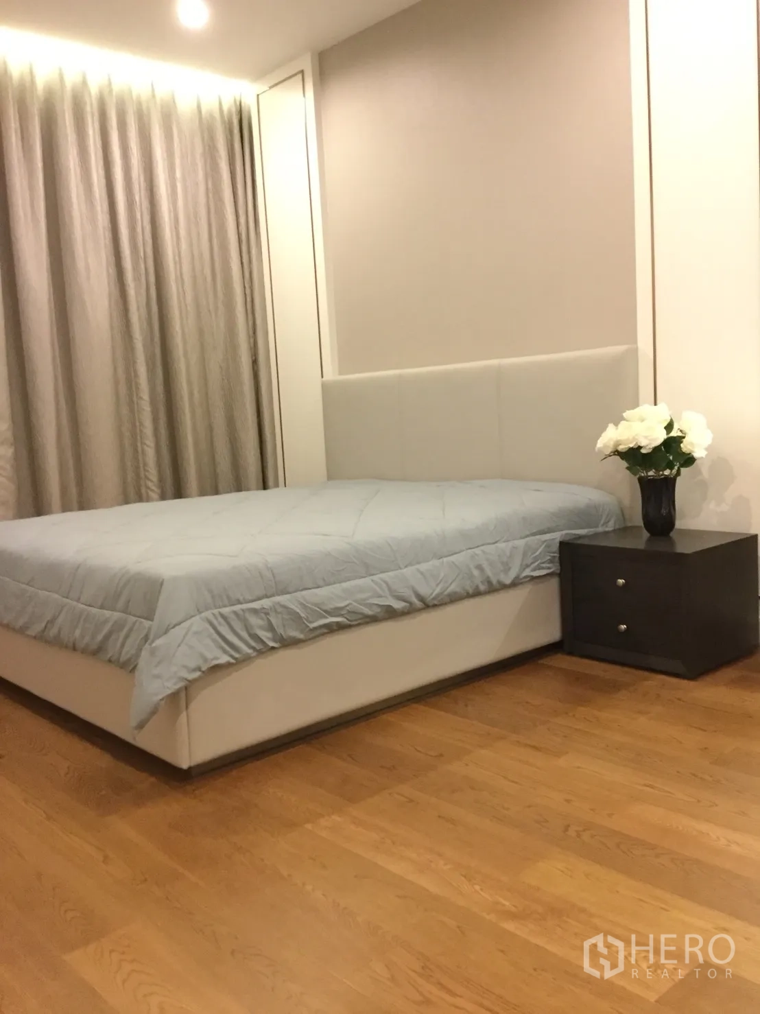 公寓 出租在Sathon, Bangkok - 温馨卧室，软包床头、床头柜、窗帘与木地板。