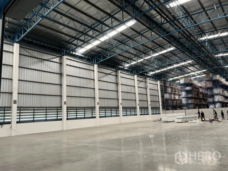 Warehouse for rent in Lat Krabang, Bangkok - Wide warehouse wall with metal cladding, ventilation louvers and high ceiling structure