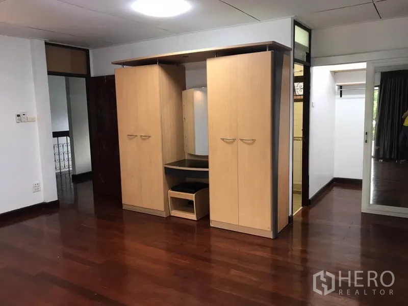 บ้าน ให้เช่าในPhra Khanong, Bangkok - ห้องนอนอีกห้องพร้อมตู้เสื้อผ้าไม้สีอ่อนและโต๊ะเครื่องแป้ง พื้นไม้เงางาม