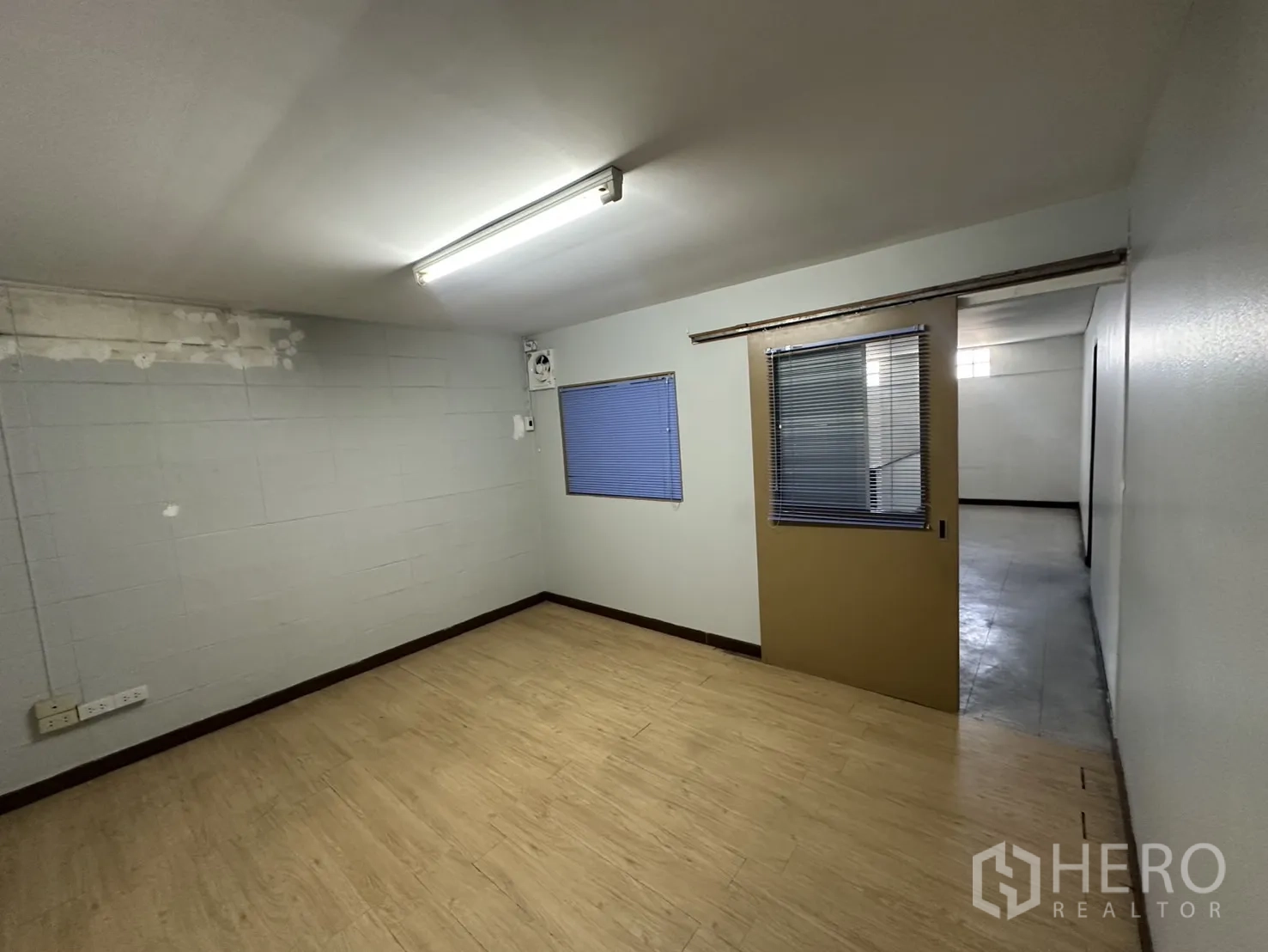 Warehouse for rent in Bang Na, Bangkok - Small office with wood-look flooring and sliding door.