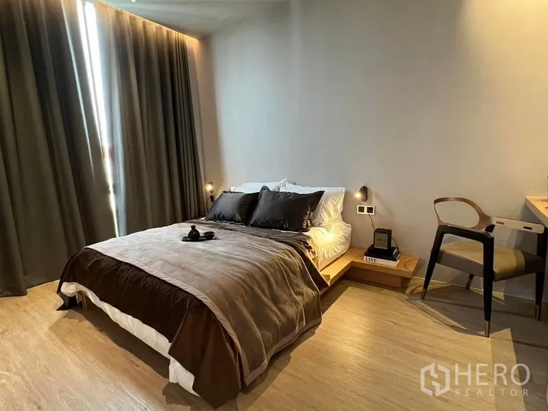 Home Office for sale in Prawet, Bangkok - Cozy bedroom with platform bed, work desk, and warm ambient lighting.