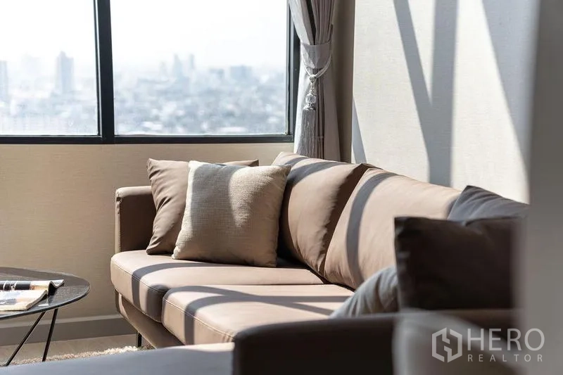 คอนโด ให้เช่าในSathon, Bangkok - ภาพระยะใกล้ของโซฟาและหมอนอิงข้างหน้าต่างบานใหญ่พร้อมวิวเมือง